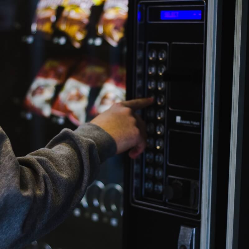 A person selects the desired item from a vending machine.